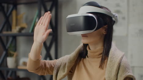 Female-engineer-in-virtual-reality-helmet-with-hands-imitates-work-of-interface.-Designing-the-future-the-concept-of-virtual-architecture-and-design-interface-graphic-applications.